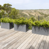Gray Jort fiberstone planter by Pottery Pots displayed in a natural outdoor setting, showcasing its sleek design.
