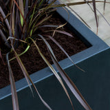 Black Jort Fiberstone planter by Pottery Pots, showcasing a sleek, modern design with a textured finish.
