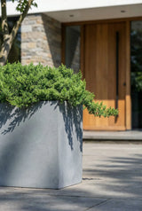Close-up of Jort Fiberstone Grau planter by Pottery Pots, showcasing its textured gray finish and modern design.