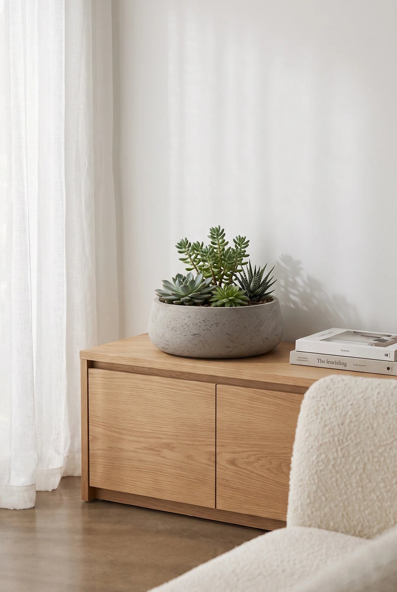 Pflanzschale Eileen Grau aus glasfaserverstärktem Ton mit Sukkulenten auf hellem Holz-Sideboard neben Vorhang || Abgebildete Größe: L